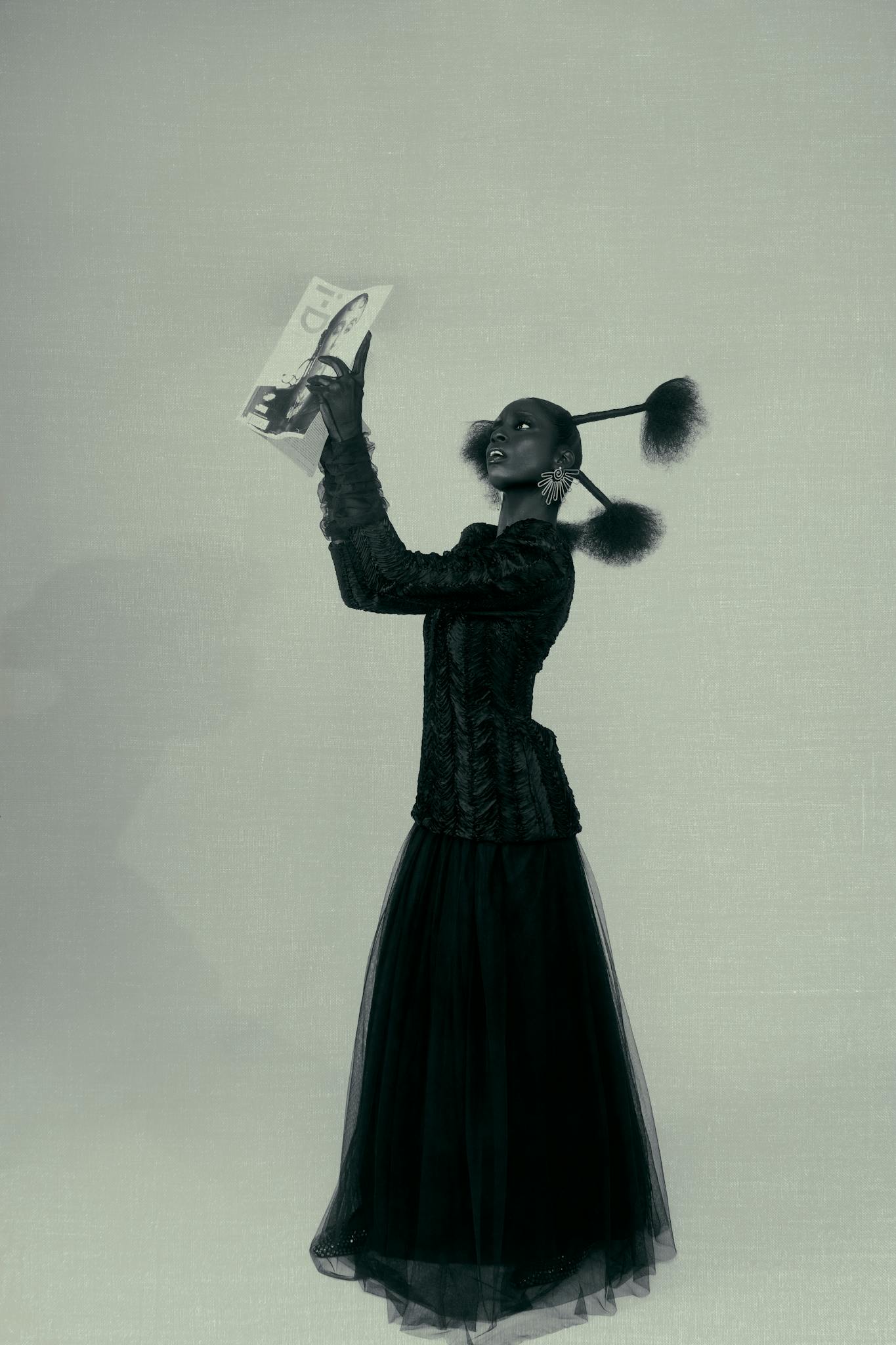 Elegant fashion portrait of a woman reading a magazine, styled with modern flair.